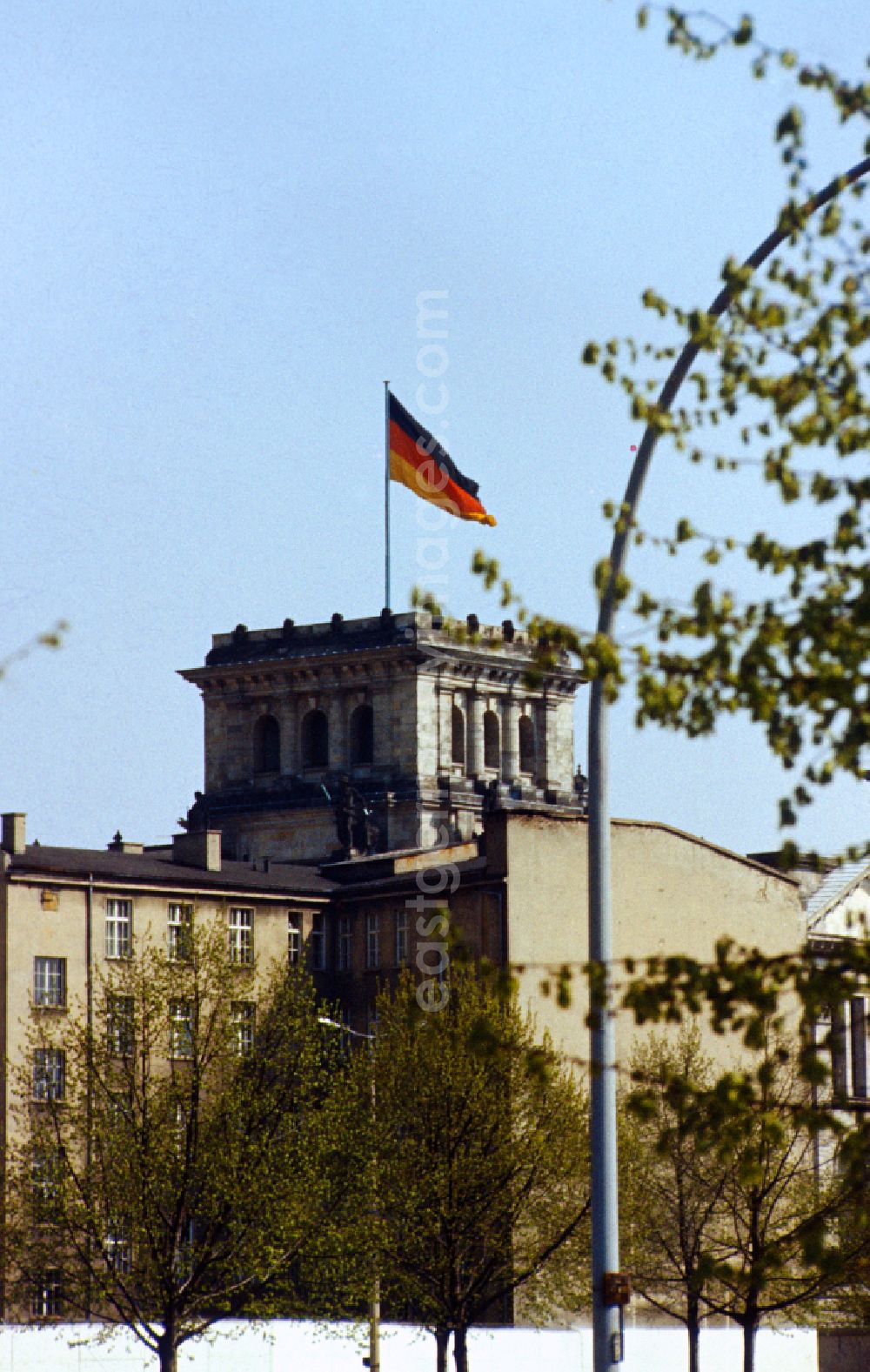 GDR photo archive: Berlin - View over the wall towards the Reichstag with tower and Germany flag in Berlin-Mitte on the territory of the former GDR, German Democratic Republic