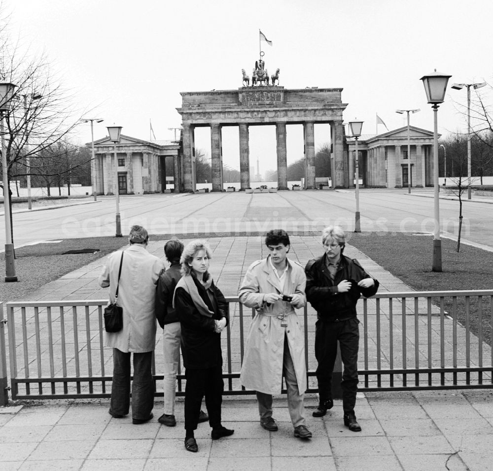 GDR picture archive: Berlin - Tourists to the fortifications at the Brandenburg Gate in Berlin, the former capital of the GDR, the German Democratic Republic. The construction of the Berlin Wall in 1961 - the bulwark of the East - belonged to the Brandenburg Gate to the border-restricted area. It became a symbol of the Cold War