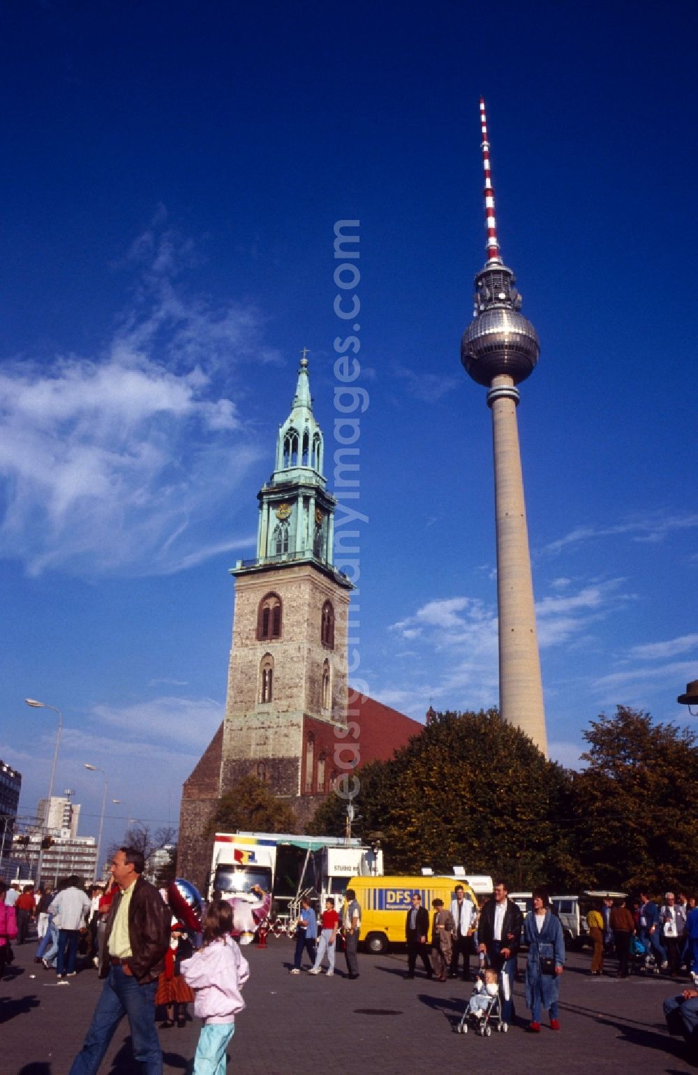 GDR picture archive: Berlin - Mitte - View of the TV tower with the Protestant Marienkirche in Berlin - Mitte. The Berlin TV Tower is the tallest building in Germany. As a politically simplistic ahmtes symbol of the GDR, the distinctive and influential city building has undergone a transition to the citywide icon in reunited Berlin