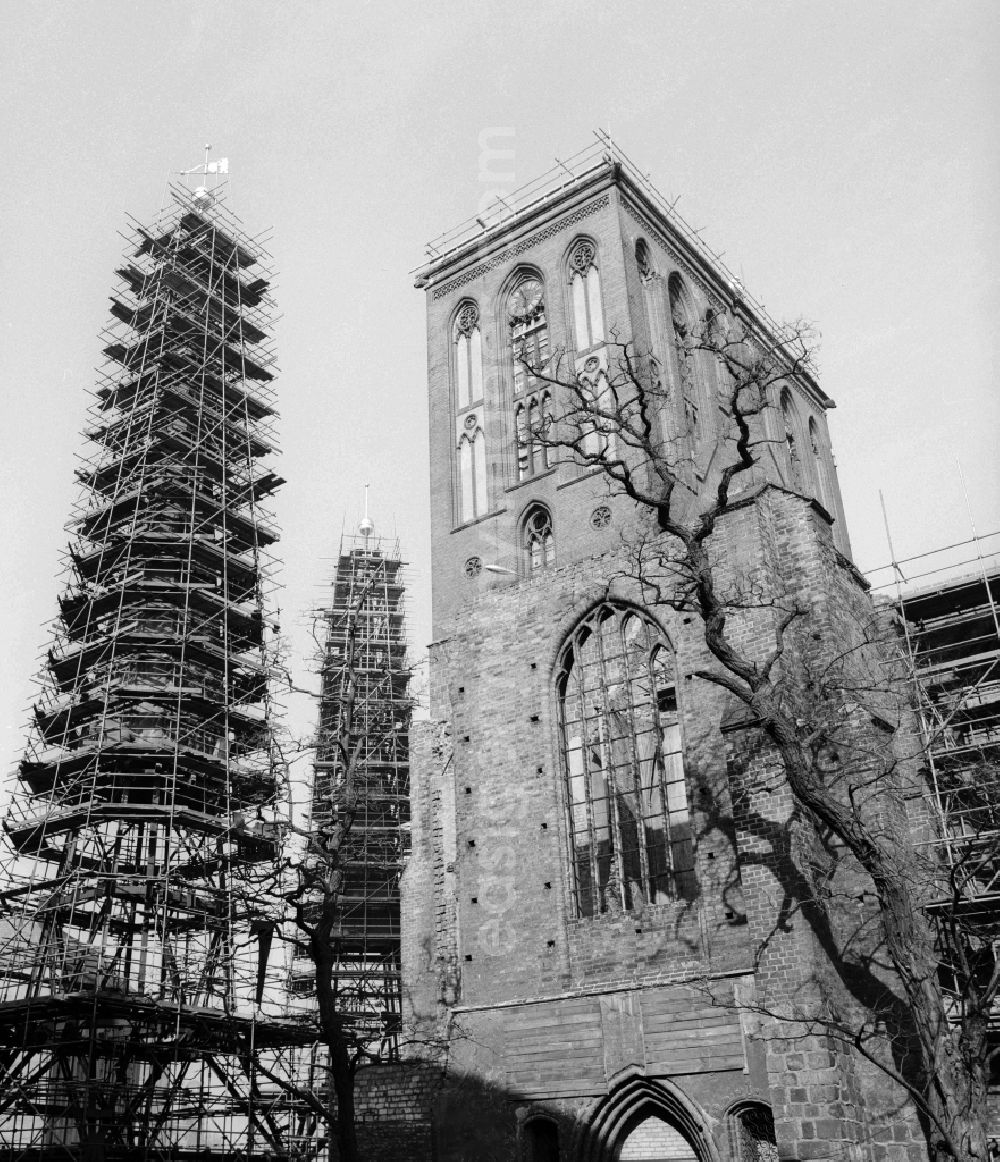 GDR image archive: Berlin - Overlooking the ruins of the Nikolai Church in Berlin, the former capital of the GDR, the German Democratic Republic. The St. Nicholas Church is the oldest church in the city and is now a listed building. Here with the two scaffolded spiers still have to be lifted onto the church roof