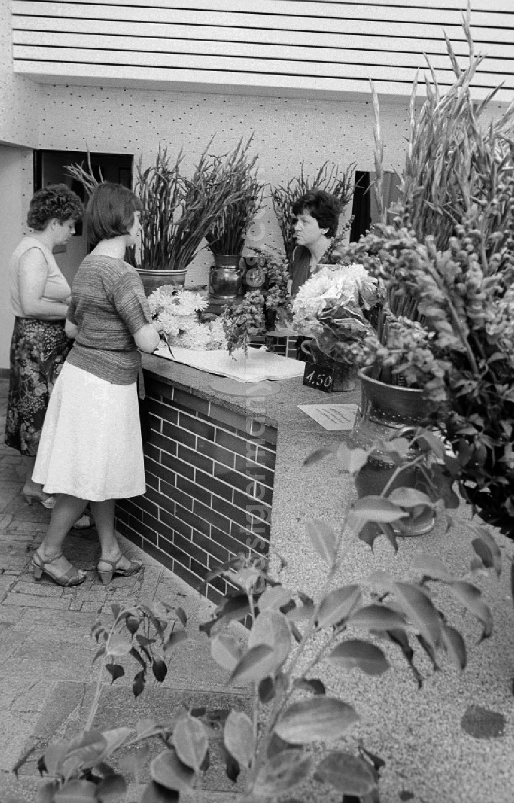 GDR picture archive: Schönefeld - Customers stand in the flower shop in the railway station airport Berlin-Schoenefeld and buy flowers in Schoenefeld in the federal state Brandenburg in the area of the former GDR, German democratic republic