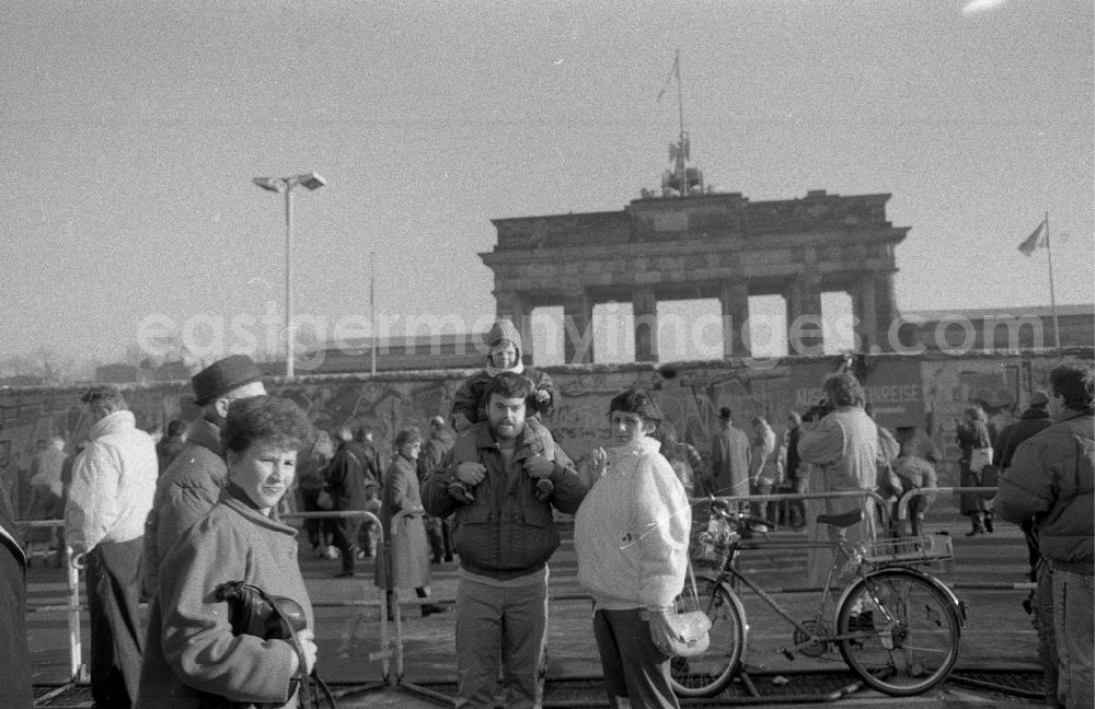 GDR picture archive: Berlin - Visitors in front of the fragments of the decaying border fortifications and wall as well as security structures in the former blocking strip of the state border at the Brandenburg Gate in Berlin West Berlin on the territory of the former GDR, German Democratic Republic