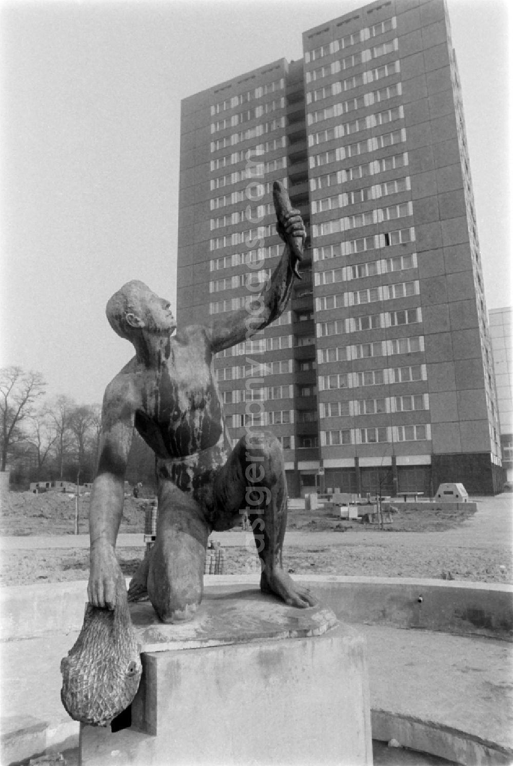 Berlin: Fountain with bronze figure Young man with fish by Hans Latt near Frankfurter Allee corner Moellendorffstrasse in Berlin Eastberlin on the territory of the former GDR, German Democratic Republic