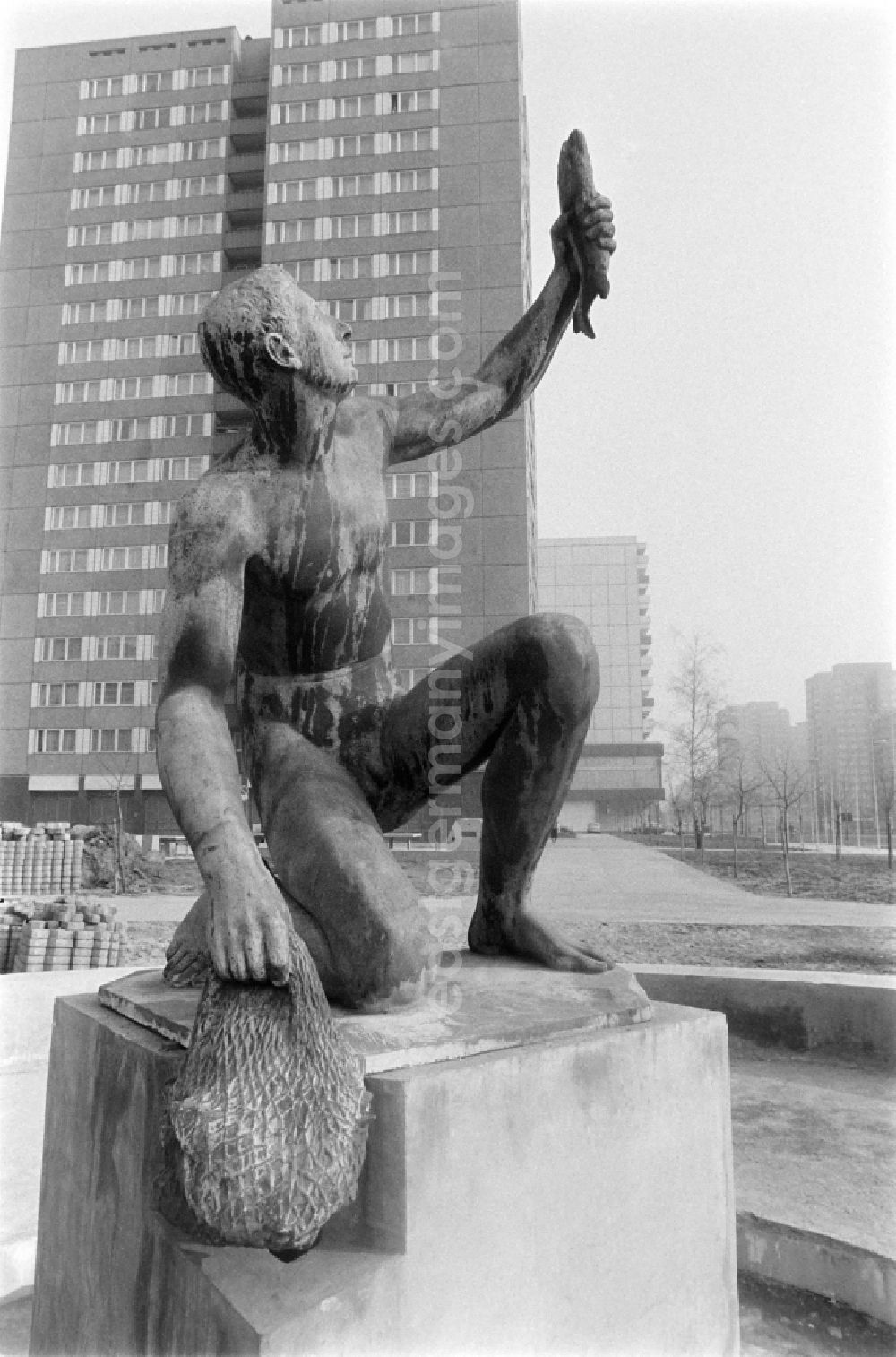 GDR photo archive: Berlin - Fountain with bronze figure Young man with fish by Hans Latt near Frankfurter Allee corner Moellendorffstrasse in Berlin Eastberlin on the territory of the former GDR, German Democratic Republic