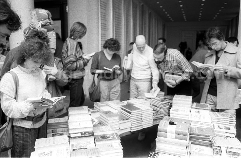 GDR picture archive: Berlin - Besucher blättern im Club der Kulturschaffenden Johannes R. Becher in ausgestellten Büchern. In dem Klub im Haus des Kulturbundes der DDR findet eine der Veranstaltungen des Tags der Künste statt. Die DDR bezeichnet sich selbst oft als Lese- oder Buchland. Trotz riesiger Auflagen sind viele Bücher oft sehr schnell vergriffen.