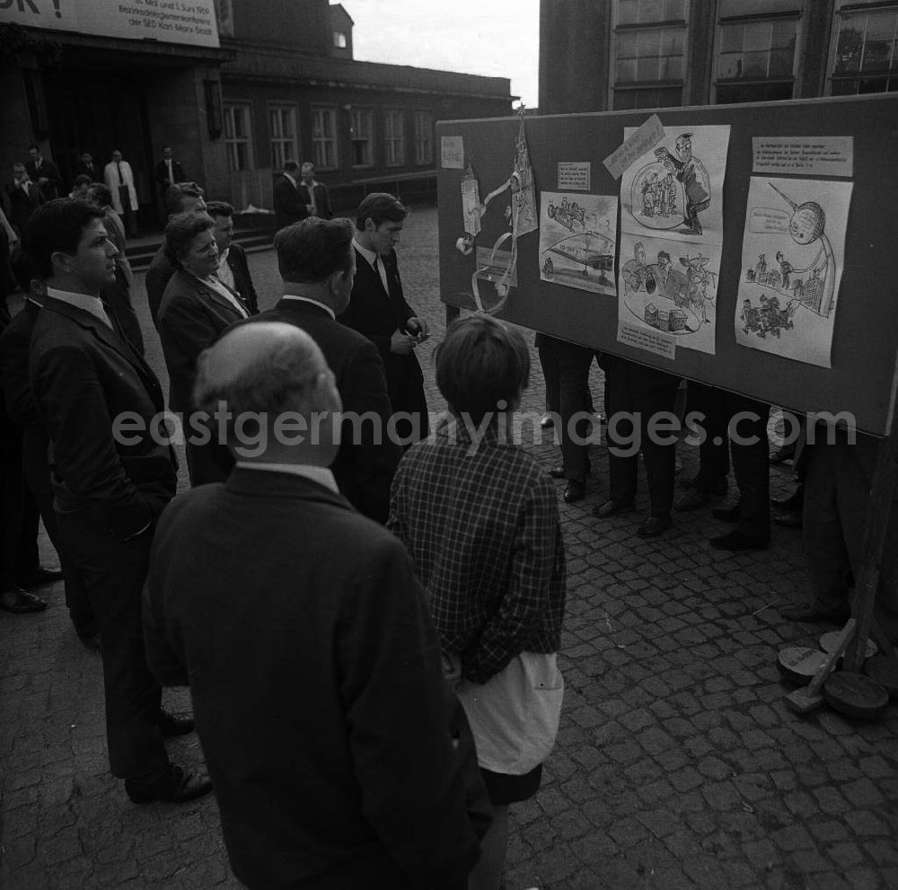 GDR picture archive: Chemnitz - Bezirksdelegiertenkonferenz der SED. Delegierte betrachten eine satirische Wandzeitung zur Entwicklung in Bezirk und Republik.