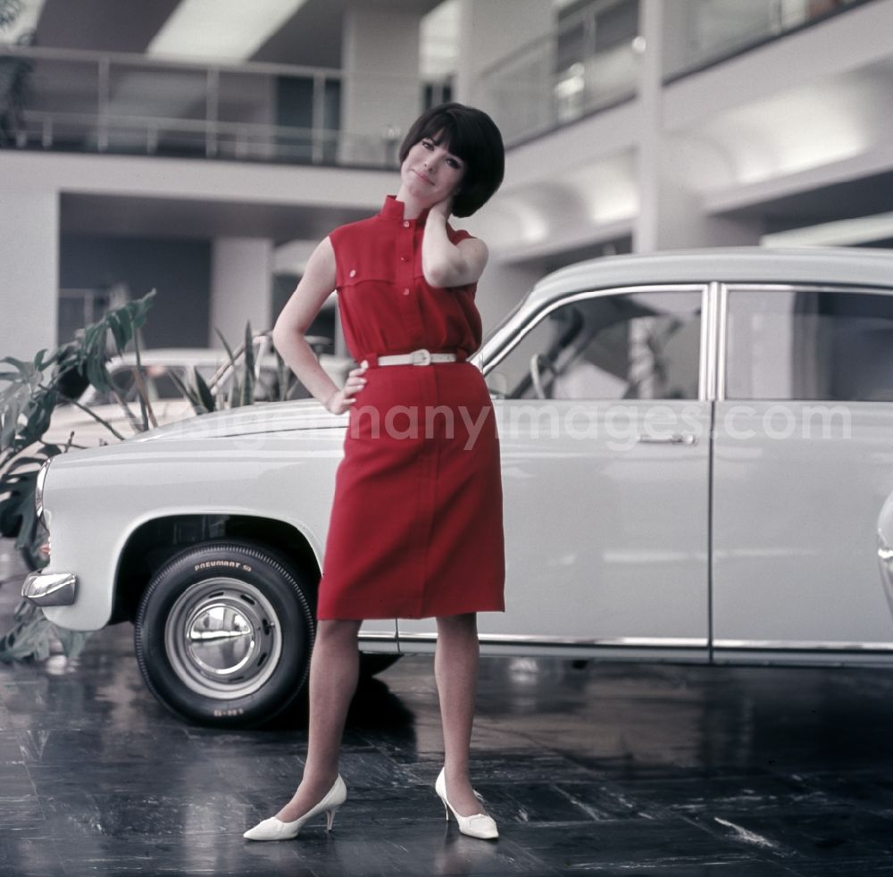 Berlin: Young woman presents current women's fashion collection in front of a Trabant P5