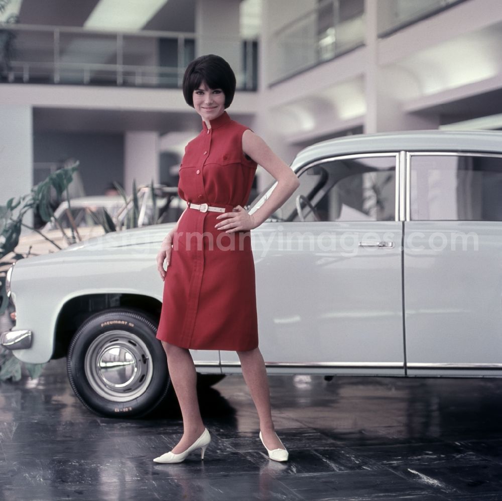 GDR image archive: Berlin - Young woman presents current women's fashion collection in front of a Trabant P5