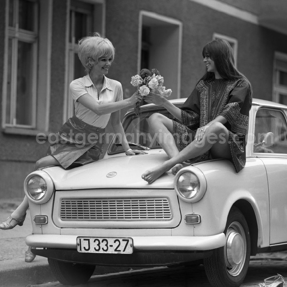 GDR photo archive: Berlin - Young woman presents current women's fashion collection summer fashion in front of a Trabant P 6