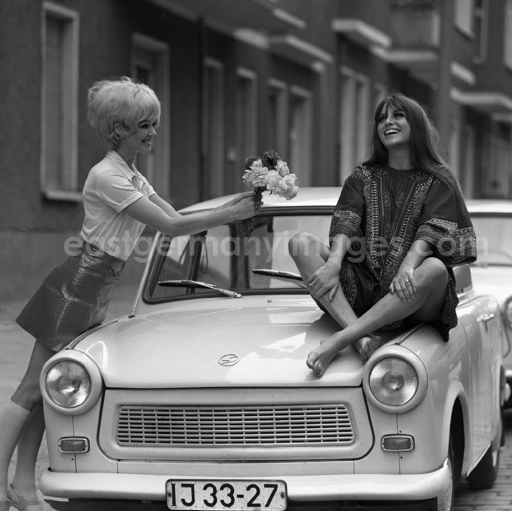 GDR picture archive: Berlin - Young woman presents current women's fashion collection summer fashion in front of a Trabant P 6