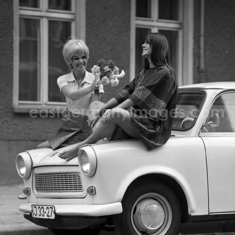 GDR photo archive: Berlin - Young woman presents current women's fashion collection summer fashion in front of a Trabant P 6