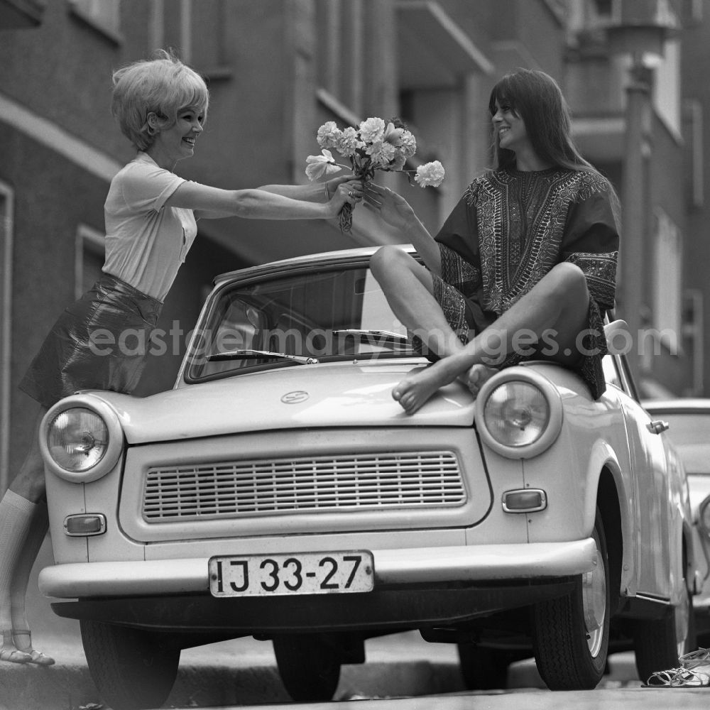 Berlin: Young woman presents current women's fashion collection summer fashion in front of a Trabant P 6