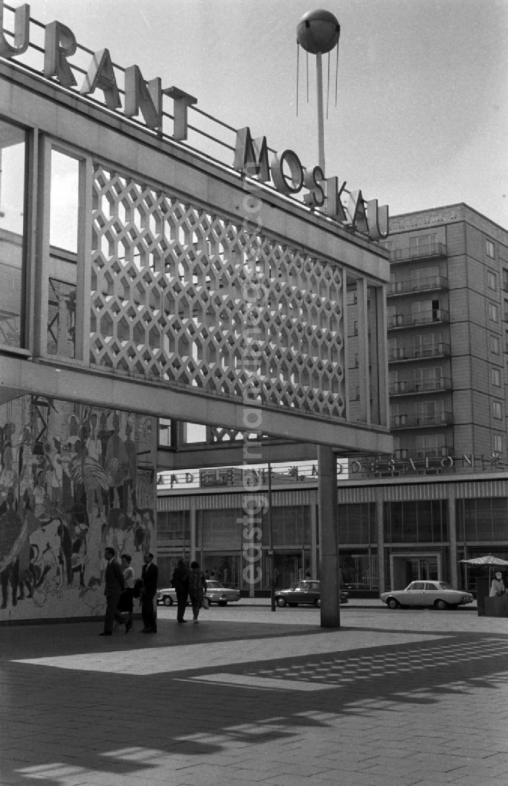 GDR image archive: Berlin - Friedrichshain - The listed building of Moscow Cafe in the Karl-Marx-Allee is located opposite the cinema International in Berlin - Mitte. The Sputnik in size was mounted on the facade is a gift of the then Ambassador of the USSR in the GDR. Striking is the open atrium design of the building. The entrance to the Karl-Marx-Allee is decorated with a large mosaic entitled The life of the peoples of the Soviet Union