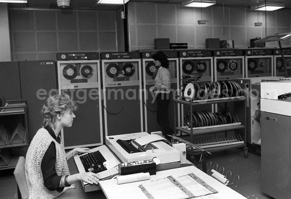 GDR photo archive: Erfurt - Zwei junge Frauen in einem Datenverarbeitungsbetrieb VEB Robotron-Optima Erfurt. Eine Frau sitzt an Schreibgerät / Schreibmaschine und eine stehet an Abspieleräten für Magnetbänder.