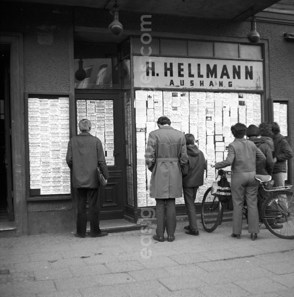 GDR photo archive: Berlin - Passanten stehen vor einem Geschäft in der Schönhauser Allee in Berlin-Prenzlauer Berg und studieren die ausgehängten Anzeigen auf der Suche nach einer günstigen Gelegenheit. Da in der DDR viele Produkte zur sogenannten Mangelware gehörten, wurde die Möglichkeit des An- und Verkaufs bzw. Tauschs vielfach genutzt. Die Anzeigen erschienen in den Zeitungen und Zeitschriften, oft wurden auch öffentliche Aushänge - die Annoncentafeln - genutzt.