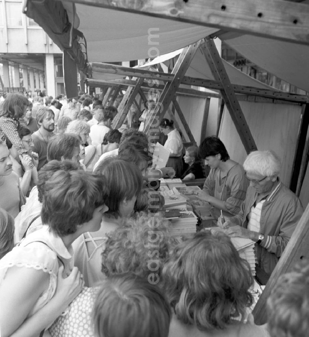 GDR photo archive: Potsdam - Der Schriftsteller Benno Pludra (r.) an seinem Büchertisch mit Besuchern auf dem Schriftstellerbasar in Potsdam.