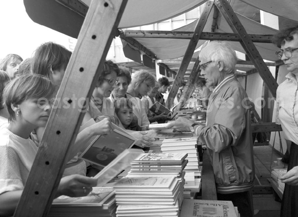 GDR picture archive: Potsdam - Der Schriftsteller Benno Pludra (r.) an seinem Büchertisch mit Besuchern auf dem Schriftstellerbasar in Potsdam.