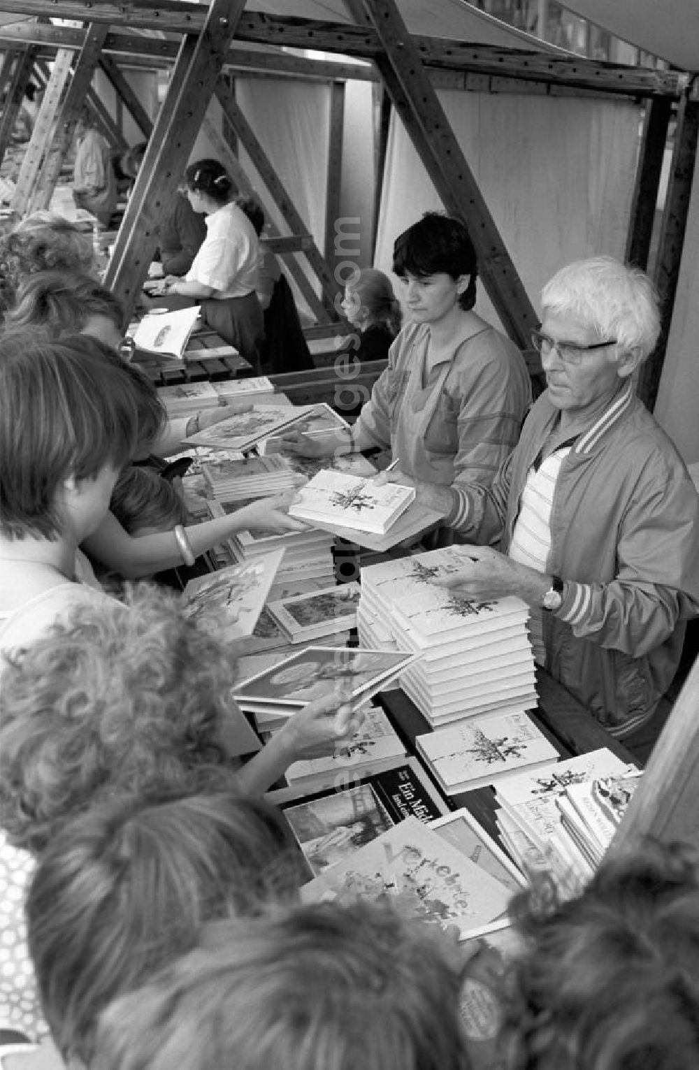 GDR photo archive: Potsdam - Der Schriftsteller Benno Pludra (r.) an seinem Büchertisch mit Besuchern auf dem Schriftstellerbasar in Potsdam.