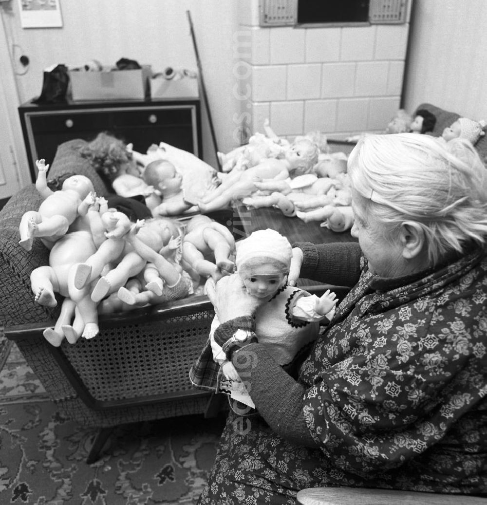 Berlin: In ihrer Wohnung in Berlin übernimmt eine alte Frau die Reparatur von verschiedenartigen Puppen. In der DDR wurde der Beruf des Puppendoktor populär durch die Sendung Zu Besuch bei Frau Puppendoktor Pille, die einmal wöchentlich im Abendgruß des Sandmännchen im Fernsehen der DDR (DFF) lief.