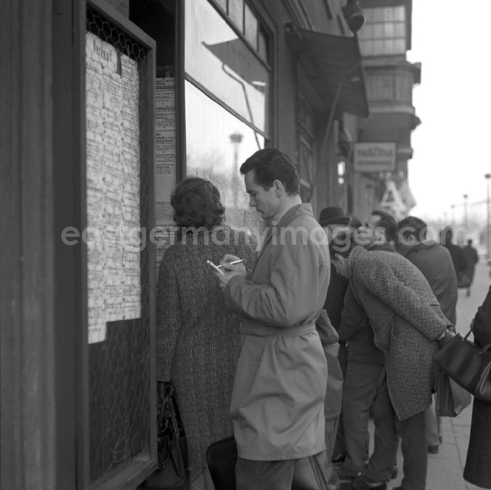 GDR image archive: Berlin - Passanten stehen vor einem Geschäft in der Schönhauser Allee in Berlin-Prenzlauer Berg und studieren die ausgehängten Anzeigen auf der Suche nach einem Schnäppchen. Die Schönhauser Allee gehörte zu den beliebtesten Einkaufsstraßen im Berliner Osten.
