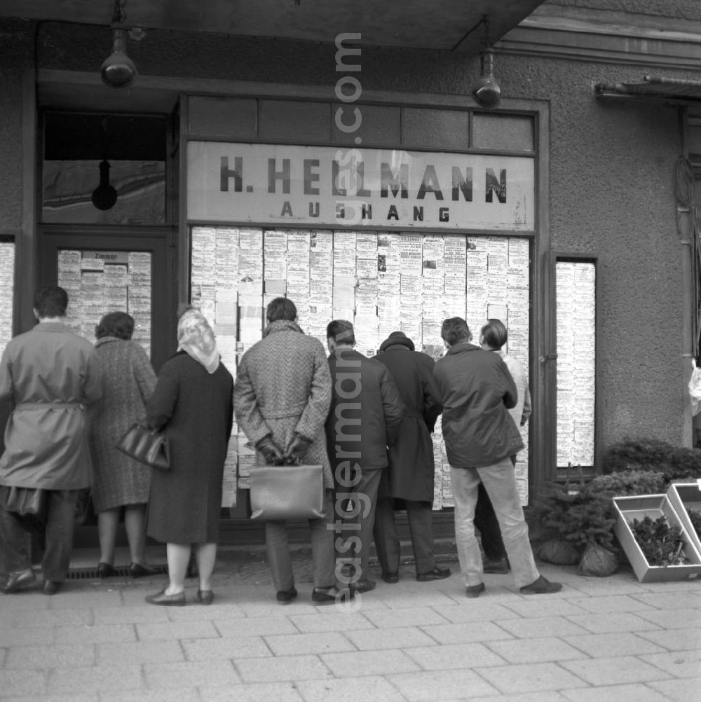 Berlin: Passanten stehen vor einem Geschäft in der Schönhauser Allee in Berlin-Prenzlauer Berg und studieren die ausgehängten Anzeigen auf der Suche nach einem Schnäppchen. Die Schönhauser Allee gehörte zu den beliebtesten Einkaufsstraßen im Berliner Osten.