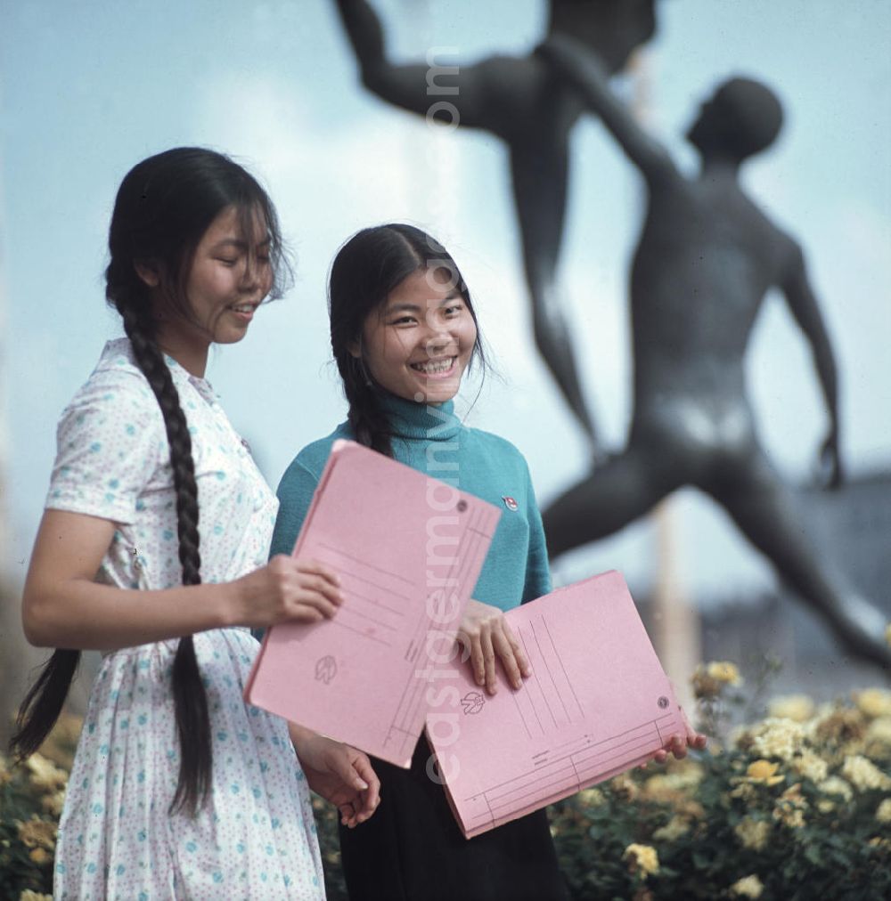 GDR picture archive: Leipzig - Junge Vietnamesinnen posieren mit ihren Unterlagen für den Fotografen. Vietnamesen bildeten in der DDR die größte Gruppe an Arbeitskräften aus den sozialistischen Bruderländern.