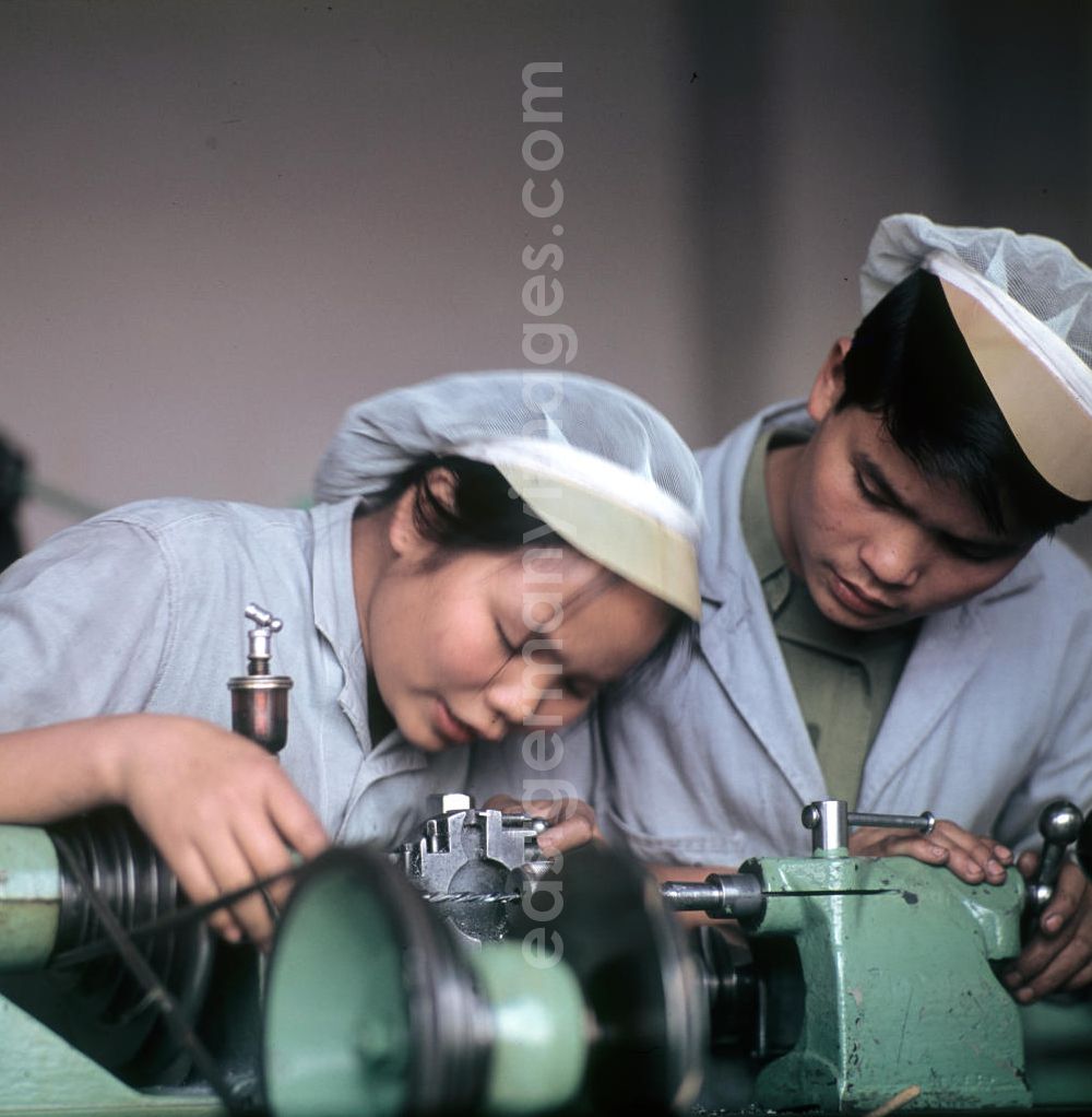 GDR image archive: Saalfeld - Vietnamesische Praktikanten arbeiten an einem Schraubstock bei der Ausbildung im Zweigbetrieb Saalfeld des VEB Carl Zeiss Jena. Vietnamesen bildeten in der DDR die größte Gruppe an Arbeitskräften aus den sozialistischen Bruderländern.
