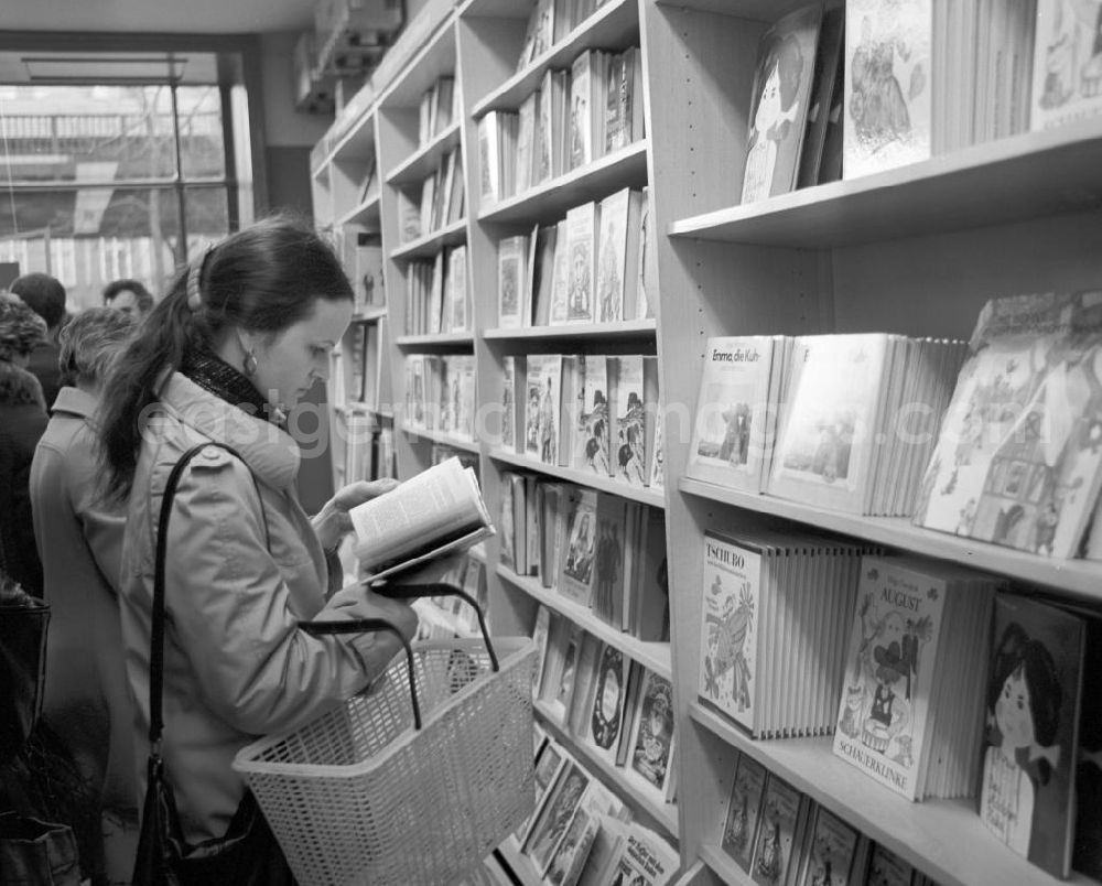 GDR image archive: Berlin - Eine Frau blättert in der Kinderbuchabteilung der Kleist Buchhandlung in Berlin in einem Buch.