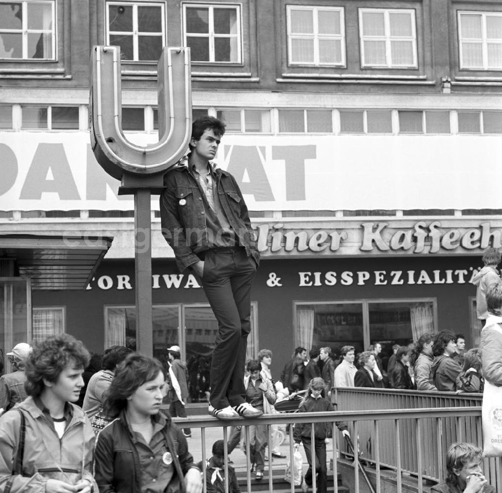 GDR image archive: Berlin - Zum Pfingsttreffen der FDJ in Berlin beobachtet ein Jugendlicher vom Geländer des U-Bahn-Eingangs das Treiben auf dem Alexanderplatz. Bei den alle fünf Jahre stattfindenden Pfingsttreffen kamen Zehntausende delegierte Mitglieder der FDJ aus der ganzen DDR zusammen.