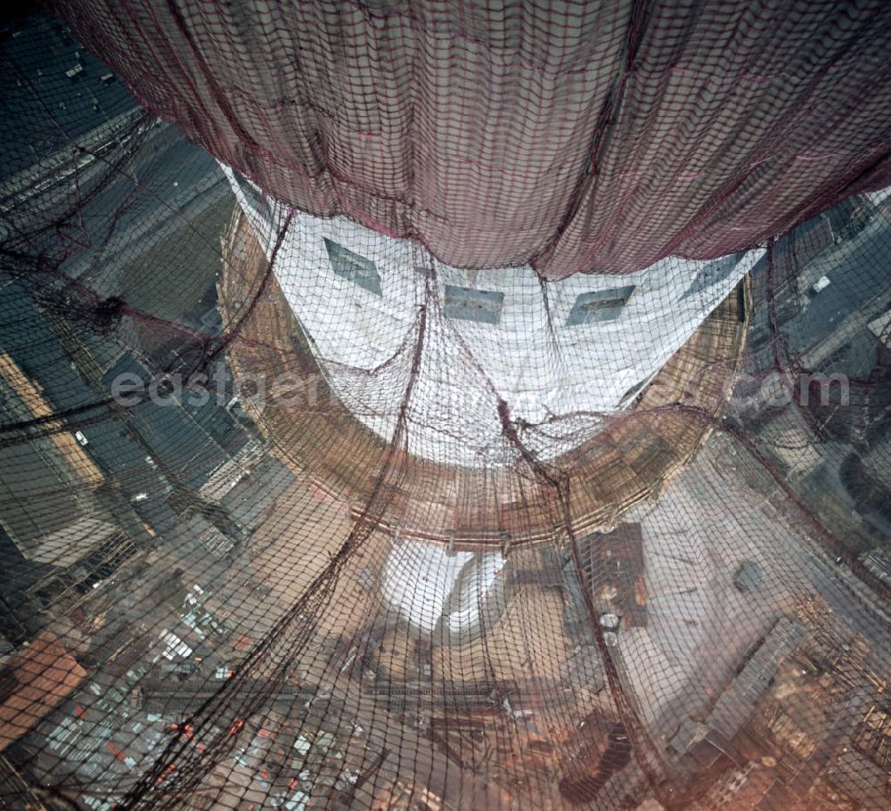 GDR photo archive: Berlin - Blick durch die Fangnetze auf den Schaft des im Bau befindlichen Fernsehturms in Berlin. In nur 52-monatiger Bauzeit wurde das über 300 Meter hohe Bauwerk im Zentrum von Ost-Berlin errichtet und am