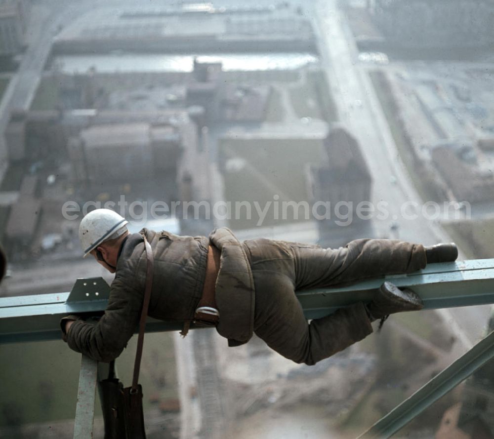GDR photo archive: Berlin - Ein Bauarbeiter bei der Montage in luftiger Höhe am Fernsehturm in Berlin. Im Hintergrund ist das Gelände des Marienviertels (heute Marx-Engels-Forum) zu erkennen.