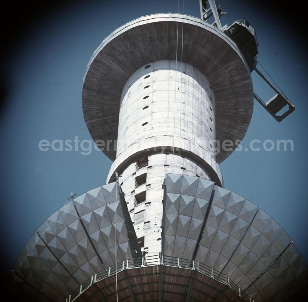 GDR picture archive: Berlin - Die Segmente der Kugel des Fernsehturms in Berlin werden mit einem Spezialkran nach oben transportiert und dann montiert. Die erste Reihe der Kugel ist fast abgeschlossen.