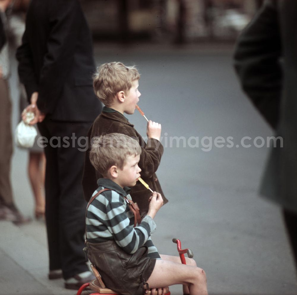 Berlin: Kinder essen einen Lutscher und warten in der Dimitroffstraße, heute Danziger Straße, in Berlin auf die Fahrer der ersten Etappe der 21. Internationalen Friedensfahrt. Die Friedensfahrt 1968 begann in Berlin und führte über Prag nach Warschau.
