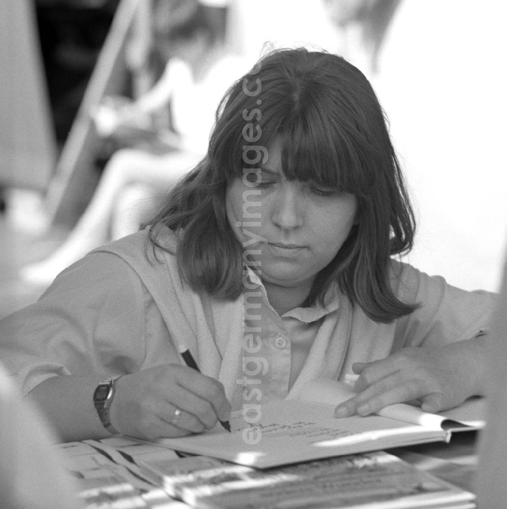 GDR picture archive: Berlin - Die Schriftstellerin Gabriele Stave signiert auf dem Schriftstellerbasar in Berlin ein Buch.