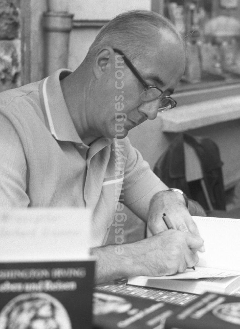 GDR picture archive: Rostock - Der Schriftsteller Gerhard Grümmer (Pseudonym: Gerhard Meer) signiert sein Buch auf dem Schriftstellerbasar in Rostock.
