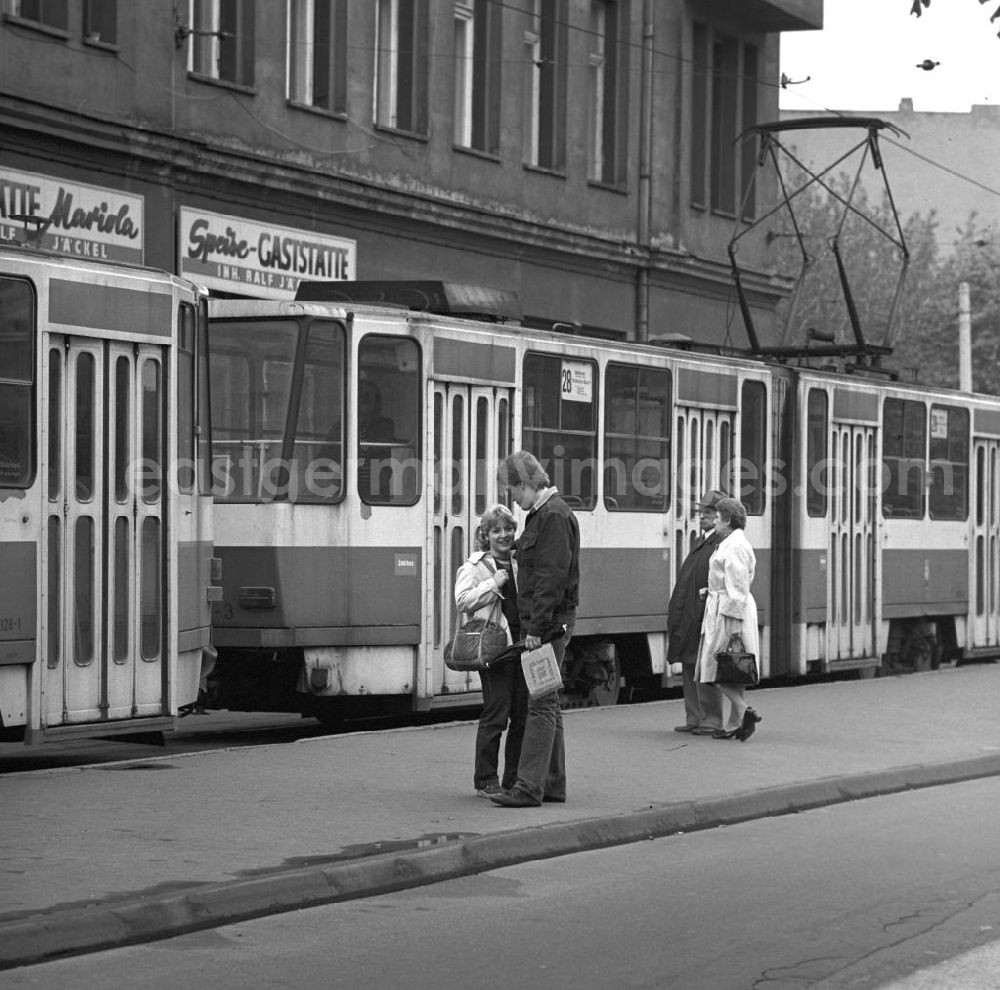 GDR picture archive: Berlin - Nach dem Besuch auf dem Schriftstellerbasar auf dem Bebelplatz in Berlin steht ein Liebespaar an einer Haltestelle der Straßenbahnlinie 28.