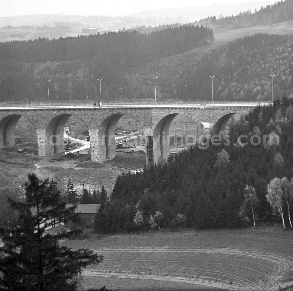 GDR picture archive: Hirschberg - Blick auf den wiederaufgebauten Teil der Autobahnbrücke über die Saale zwischen Hirschberg (Thüringen) und Rudolphstein (Bayern). Die Brücke war am Ende des Zweiten Weltkrieges stark beschädigt, ein Bogen im April 1965 gesprengt worden. Die Instandsetzung erfolgte nach einem Vertrag zwischen der DDR und der BRD, die die Finanzierung des Baus übernahm. Im Hinterland der DDR wurden die Abfertigungsgebäude für die Grenzübergangsstelle (GÜST) Hirschberg errichtet, der Autobahn-Grenzübergang im Dezember 1966 eröffnet. Nach der Wiedervereingung erfolgte der Rückbau der Anlagen und die Erweiterung der Brücke durch den dreispurigen Ausbau der A9. Sie heißt heute auch Brücke der Deutschen Einheit.