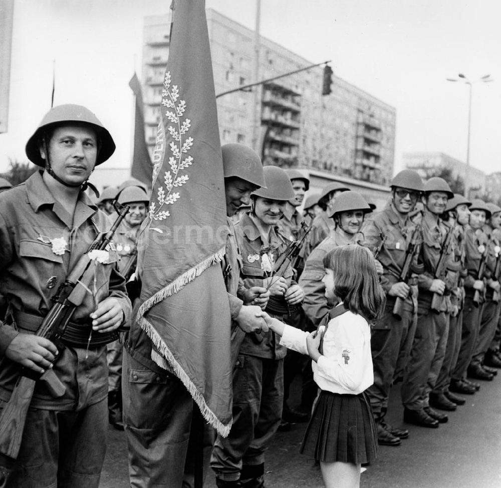GDR picture archive: Berlin - Mitglieder der Kampfgruppen der DDR sind zu einer Parade zum 15. Jahrestag des Baus des antifaschistischen Schutzwalls in der Karl-Marx-Allee in Berlin angetreten. Die paramilitärischen Kampfgruppen waren an der Errichtung der Berliner Mauer am 13. August 1961 maßgeblich beteiligt.