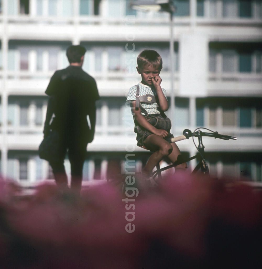 GDR picture archive: Halle / Saale - Ein Junge sitzt auf seinem Fahrrad und bohrt in der Nase in Halle-Neustadt. Am Standort der Chemieindustrie der DDR wurde in den 1960er und 197