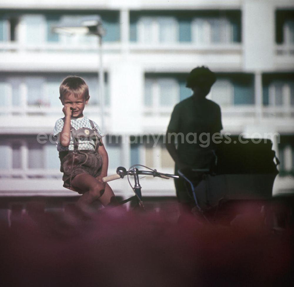GDR image archive: Halle / Saale - Ein Junge sitzt auf seinem Fahrrad und bohrt in der Nase in Halle-Neustadt. Am Standort der Chemieindustrie der DDR wurde in den 1960er und 197