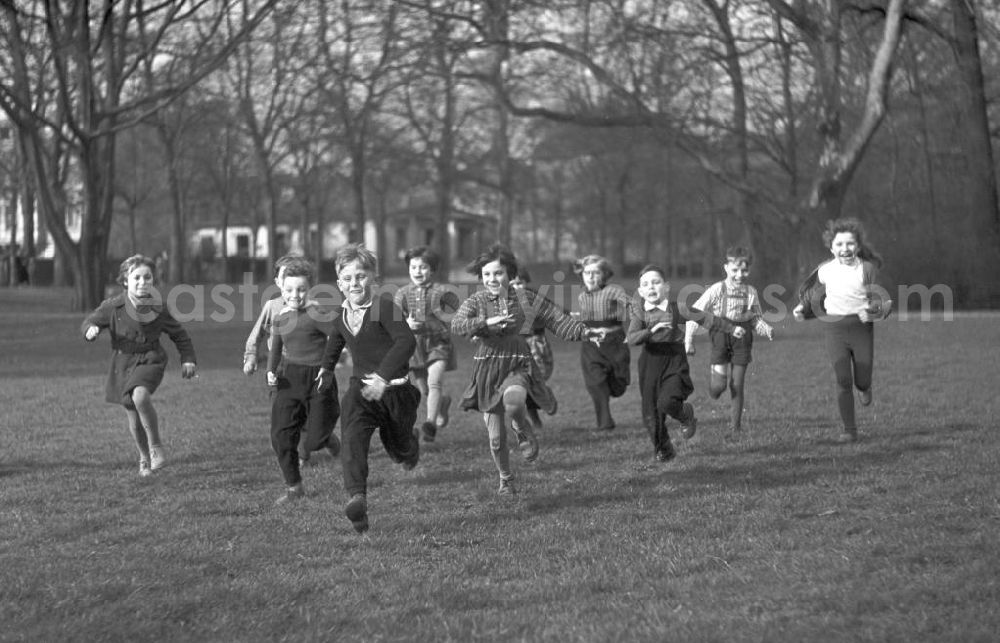 Leipzig: Eine Gruppe Vorschulkinder rennt lachend über eine Wiese im Clara-Zetkin-Park in Leipzig.