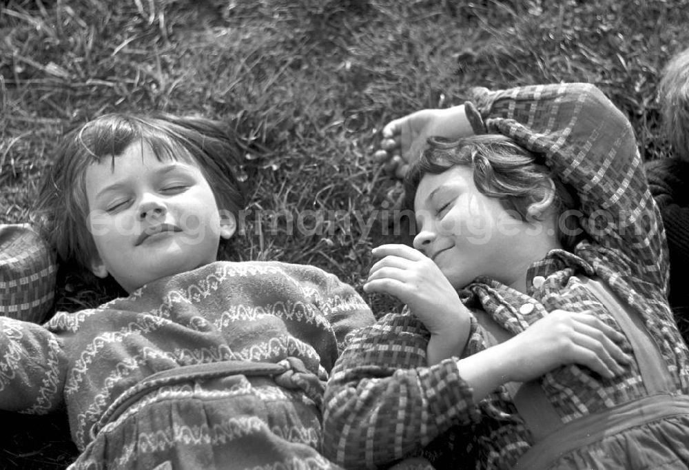 GDR image archive: Leipzig - Vorschulkinder liegen auf einer Wiese im Clara-Zetkin-Park in Leipzig und ruhen sich aus.