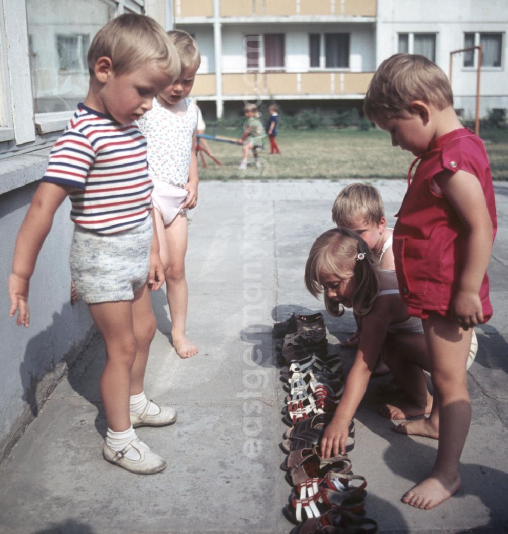 GDR photo archive: Halle an der Saale - Eine Erzieherinn kümmert sich in einem Kindergarten in Halle-Neustadt um ein kleines Kind. Am Standort der Chemieindustrie der DDR wurde in den 1960er und 197
