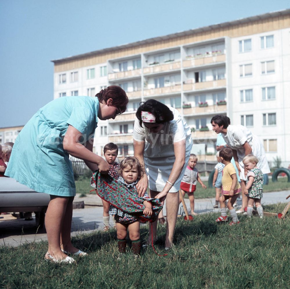 GDR photo archive: Halle an der Saale - Zwei Erzieherinnen kümmern sich in einem Kindergarten in Halle-Neustadt um ein kleines Kind. Am Standort der Chemieindustrie der DDR wurde in den 1960er und 197