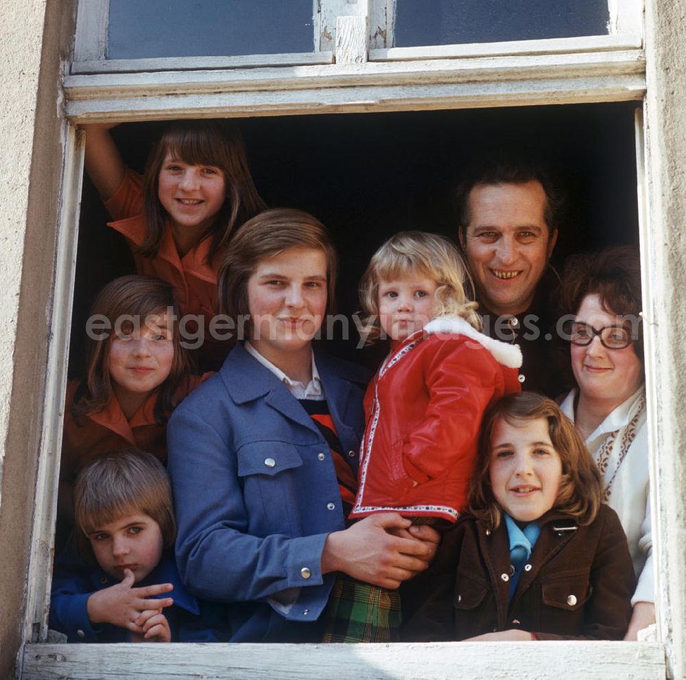 GDR picture archive: Neubrandenburg - Eine kinderreiche Familie an einem Fenster in Neubrandenburg.