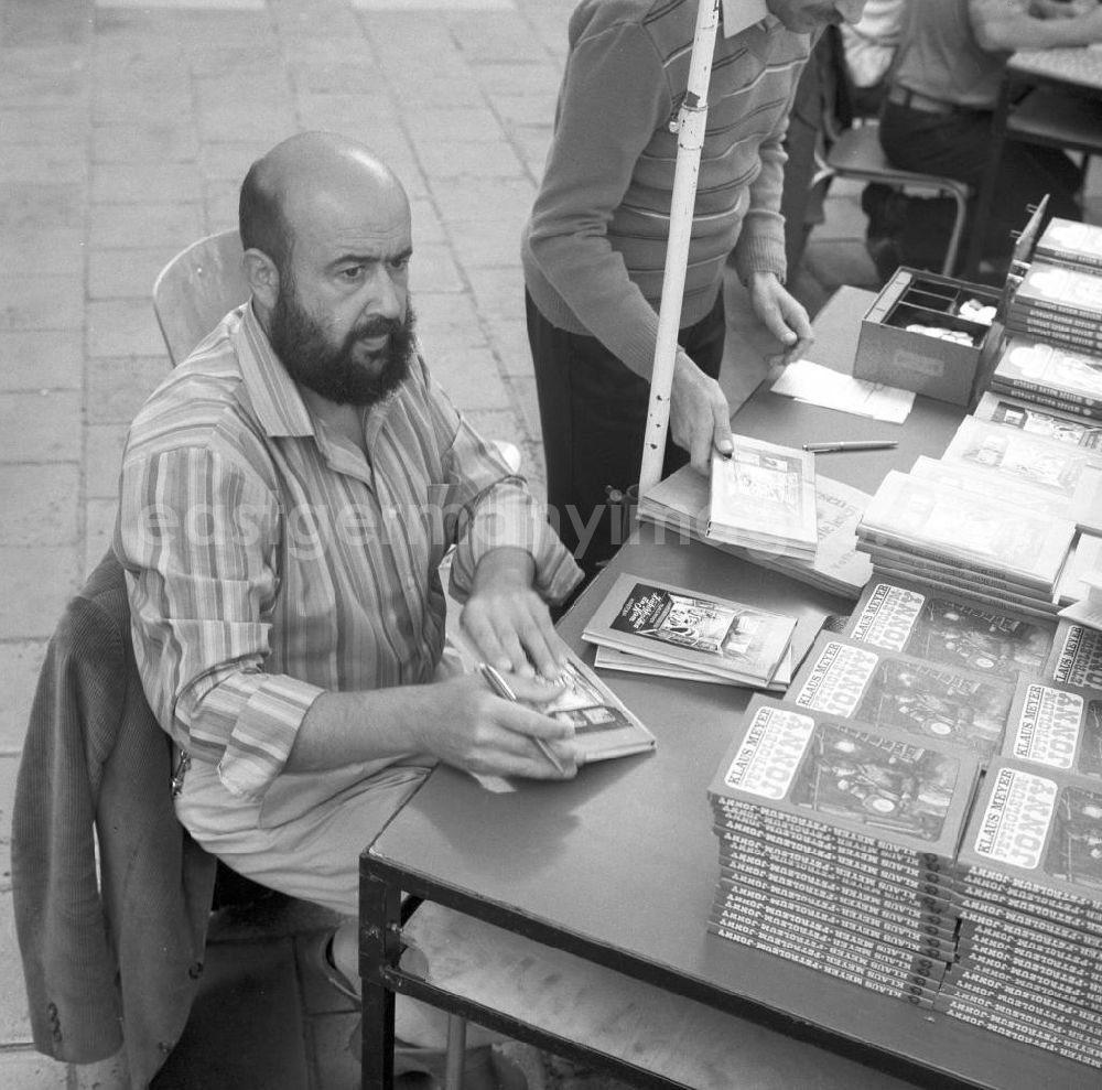 GDR picture archive: Rostock - Der Schriftsteller Klaus Meyer signiert seine Bücher auf dem Schriftstellerbasar in Rostock.