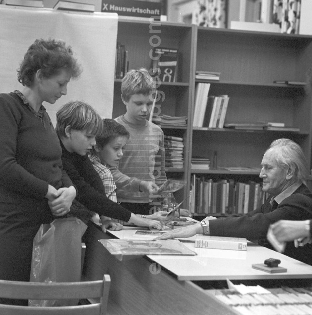 GDR photo archive: Berlin - Der Komponist Kurt Schwaen verteilt in einer Bibliothek in Berlin-Mahlsdorf an eine Schülergruppe Autogramme.