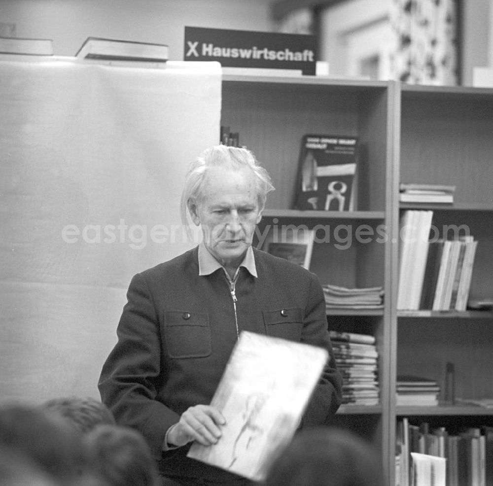 Berlin: Der Komponist Kurt Schwaen erklärt in einer Bibliothek in Berlin-Mahlsdorf einer Schülergruppe seine Musik. In der Hand hält er seine Schallplatte Pinocchios Abenteuer.