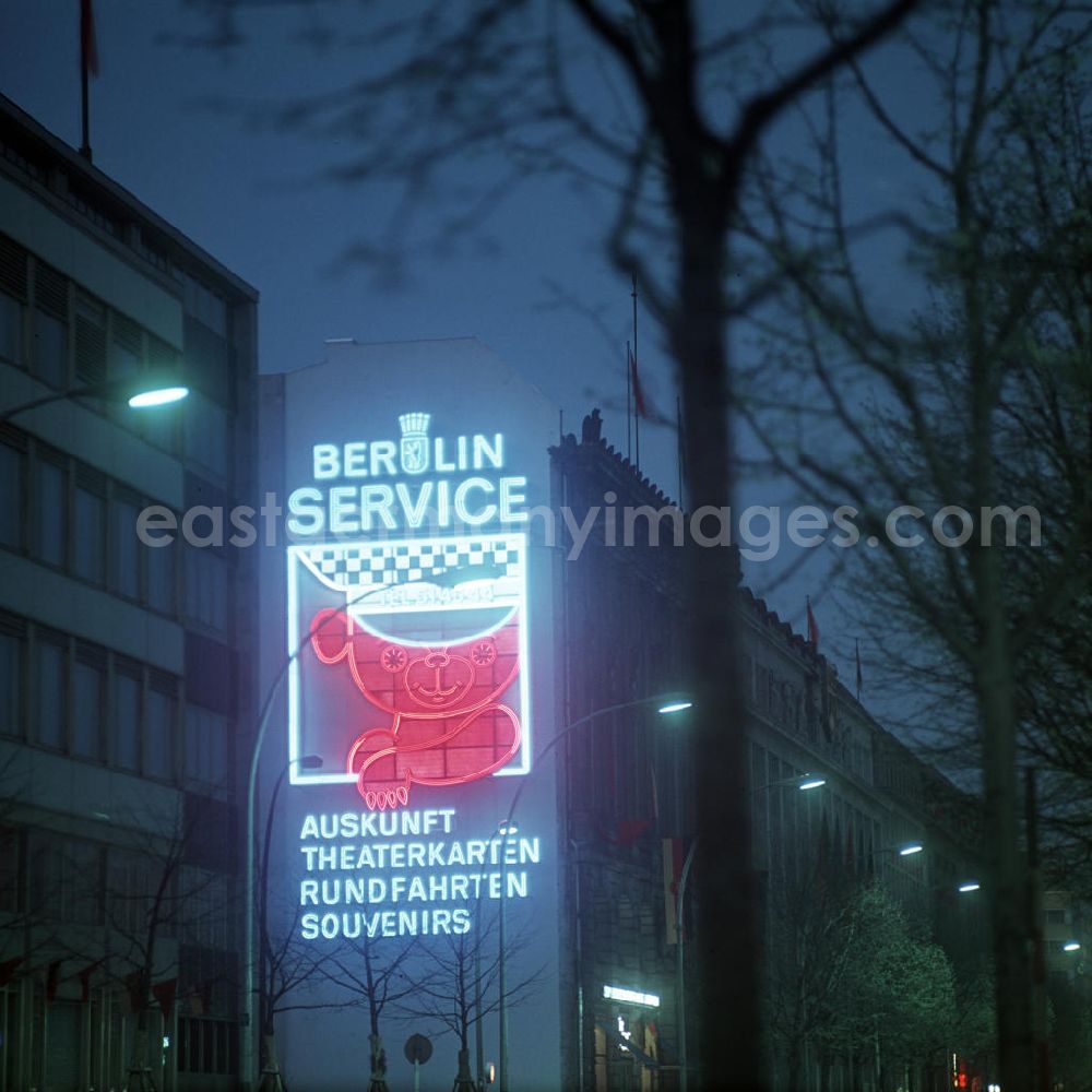 Berlin: Nachtaufnahme: Eine Leuchtreklame wirbt Unter den Linden mit einem Berliner Bären als Symbol für den Berlin Service der Hauptstadt der DDR, der Dienstleistungen in den Bereichen Auskunft, Theaterkarten, Rundfahrten und Souvenirs anbietet.