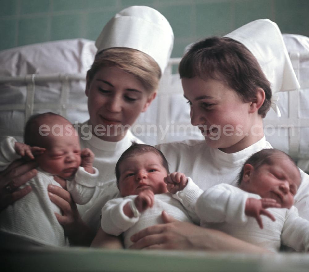 GDR image archive: Berlin - Zwei Krankenschwestern in einem Krankenhaus in Berlin-Kaulsdorf halten Neugeborene in ihren Armen.